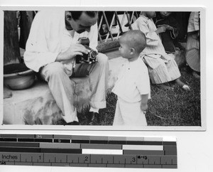 Maryknoll priest with orphan at Luoding, China, 1938