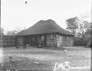 African family in front of a hut, Catembe, Mozambique, ca. 1896-1911