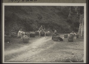 Porters at rest. They are carrying chinese persimmon (figs)