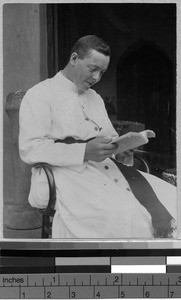 Father McCabe reading, Uganda, Africa, 1919