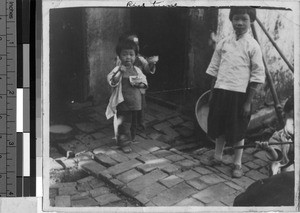 Orphans eating rice while standing, Loting, China, ca. 1935
