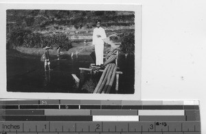 A boy crosses a bridge at Dongzhen, China, 1937