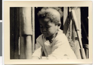 Child pounding corn, Ayra, Ethiopia