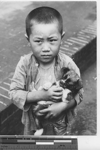 A boy and a puppy at Fushun, China, 1939