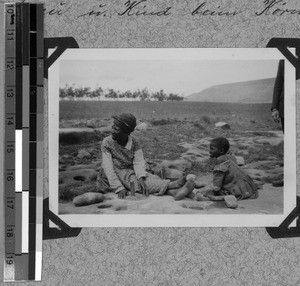 Woman and child grinding grains, South Africa East