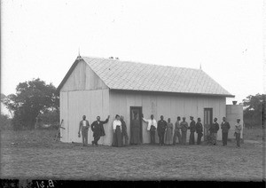 Group of people standing in front of a building, Ricatla, Mozambique, ca. 1907-1908