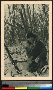 Missionary father cutting down a sapling, Canada, ca.1920-1940