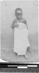 Boy standing in front of a concrete wall, Africa, May 20, 1914