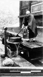 Japanese man taking water from a well, Japan, ca. 1920-1940