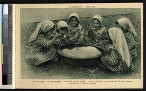 Orphan girls eating from a large bowl, Algeria, ca.1900-1930