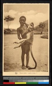 Boy holding monkey outdoors, Congo, ca.1920-1940