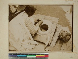 Malagasy woman plaiting a hat using rush, Madagascar, 1900