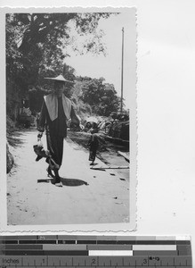 Man walking by the river at Luoding, China, 1937