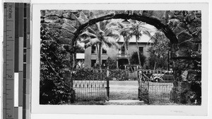 Stone archway framing a house, Hawaii, ca. 1930-1950