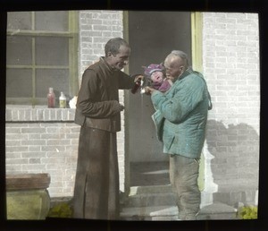 Fr. Anthony Cotta, MM, treating a baby's hand at a dispensary, China, ca. 1906-1919