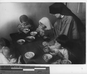 Maryknoll sister with orphans at Fushun, China, 1937