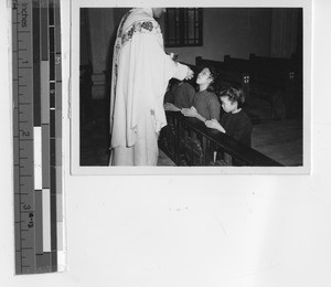 Maryknoll priest with children at Yunfu , China, 1947