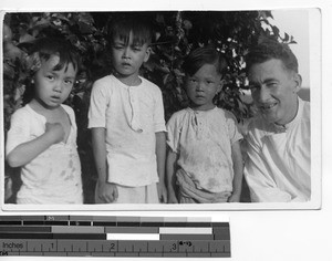 Fr. Cunneen with three children at Wuzhou, China, 1947