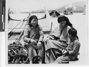 Maryknoll Sister rides in a boat with woman and child at Meixien, China, 1937