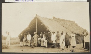 Missionary Reusch with others in front of church hut, Tanzania, ca.1923-1938