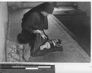 Maryknoll sister with a baby at Fushun, China, 1940