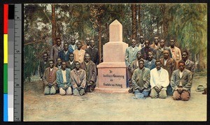 Men standing and kneeling beside a pink tombstone, South Africa, ca.1920-1940