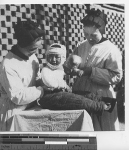 Sisters with injured child at Loyang, China, 1948