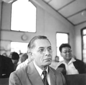 Den Lutherske Kirkesynode i Kaohsiung, 18.-19. november 1956. Pastor Bly lytter med betænkelighed. "Ja, men hvad nu, når ingen af missionsselskaberne synes, de har penge til foretagendet, og det desuden er forbudt at have kristendom som undervisningsfag?" "Kan der blive en virkelig kristen indflydelse i skolen?" (Anvendt i: Dansk Missionsblad nr 9/1957)