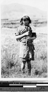 Girl standing in field, Philippines, September 1925