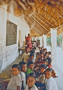 06.- Tamil Nadu, Indien, 1988-89. "Med 80 elever i klassen" - En dansk lærer i Arcot skoleprojekt fortæller: Denne skole står også over for at skulle renoveres. Taget er ved at falde sammen, og som I kan se, må to klasser sidde ude for at give plads til tre klasser indenfor. Her sidder 4. klasse så. Der er megen disciplin i de indiske skoler, så det kan godt lade sig gøre, men de glæder sig til at få en ny skolebygning