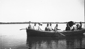 Swiss missionaries and African people on a small boat, Macaneta, Mozambique