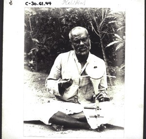 Medical mission, India. Dr Stokes. - Leprosy patient making music with an instrument he has made himself