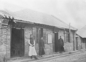 Gadekapellet i Fenghwangchen. Evangelist Dong står i læseværelsets dør. De andre to er prøvearbejderne Sun og Han. Den lille er Sun og Han den store i det lyse tøj. Han står ved kapellets dør. Danmission Photo Archive