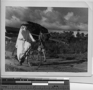 Maryknoll Sister rides a bike in Meixine, China, 1949