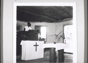 During a church service in Besongabang. The notice 'wine and beer' opposite can be seen out of the open church