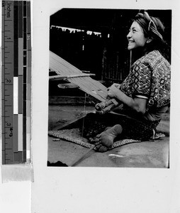 Smiling woman weaving with a backstrap loom, Guatemala, ca. 1943