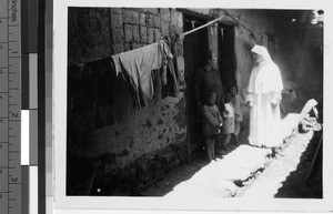 Maryknoll Sister greets a family outside their home, Kaying, China, ca. 1935