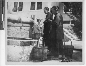 Women fetching water at Meixien, China, 1949