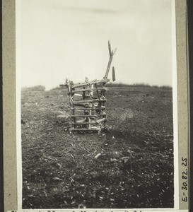 A construction on the market in Bali. A man, from whom money has been stolen, put 'medicine' down in that place, and surrounded it with this fence because of the dogs. It is expected that the thief will put the money back in the sack which hangs there - if he does not the 'medicine' will make him ill. (1928)