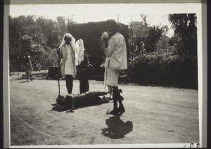 Madastana. A young woman is rolling on the floor. A temple servant plays on a horn made from a shell