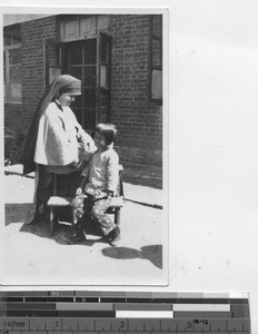 Maryknoll Sister with a little patient at Fushun, China