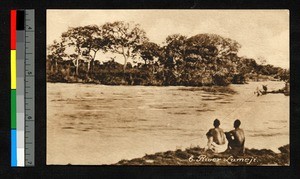 Two men sitting on a riverbank, Angola, ca.1920-1940