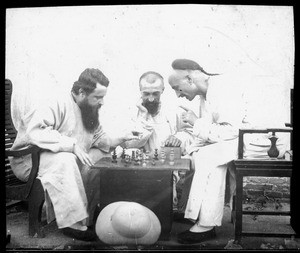 Fr. Anthony Cotta, MM, and two men playing chess, ca. 1898-1919