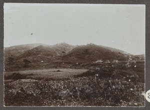 Three houses in hilly grassland, Tanzania