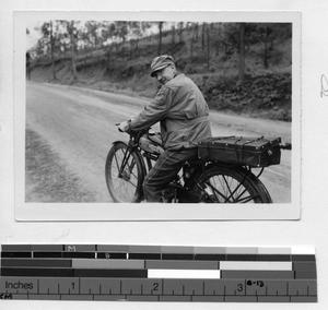 Fr. Arthur Cunneen riding a bicycle at Wuzhou, China, 1948