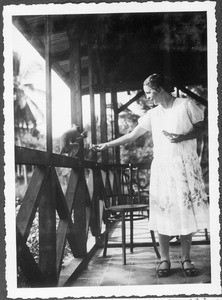 Miss Fleck feeding a monkey, Tanga, Tanzania, 1928