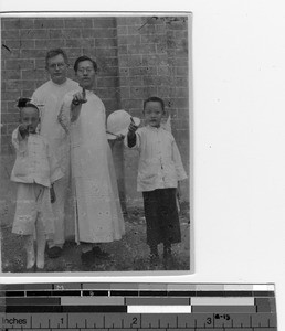 Fr. Robert Cairns, MM standing with a man and two children in China, 1929
