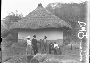 Swiss missionaries and African people in front of a hut, South Africa, ca. 1896-1911