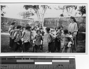 A Maryknoll Sister and children playing at the orphanage at Luoding, China, 1939