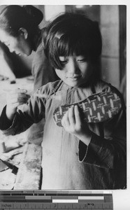 An orphan girl making a shoe at Fushun, China, 1940